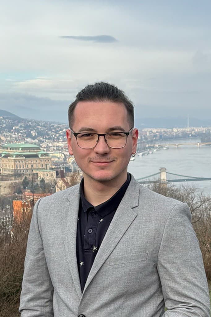 Csaba Ovari in Budapest, with Buda Castle and the Danube behind him